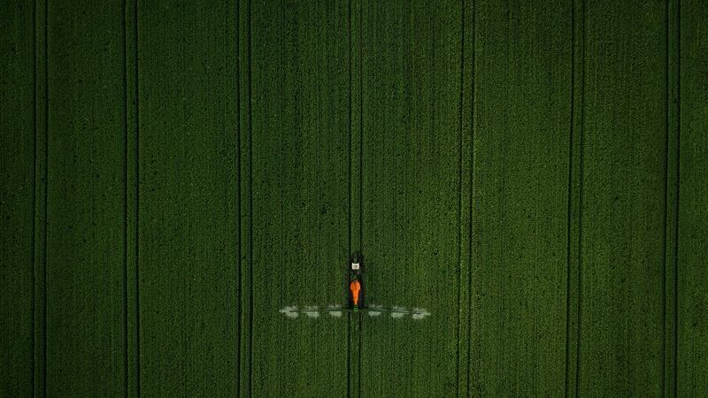 A farmer spraying fertilizer