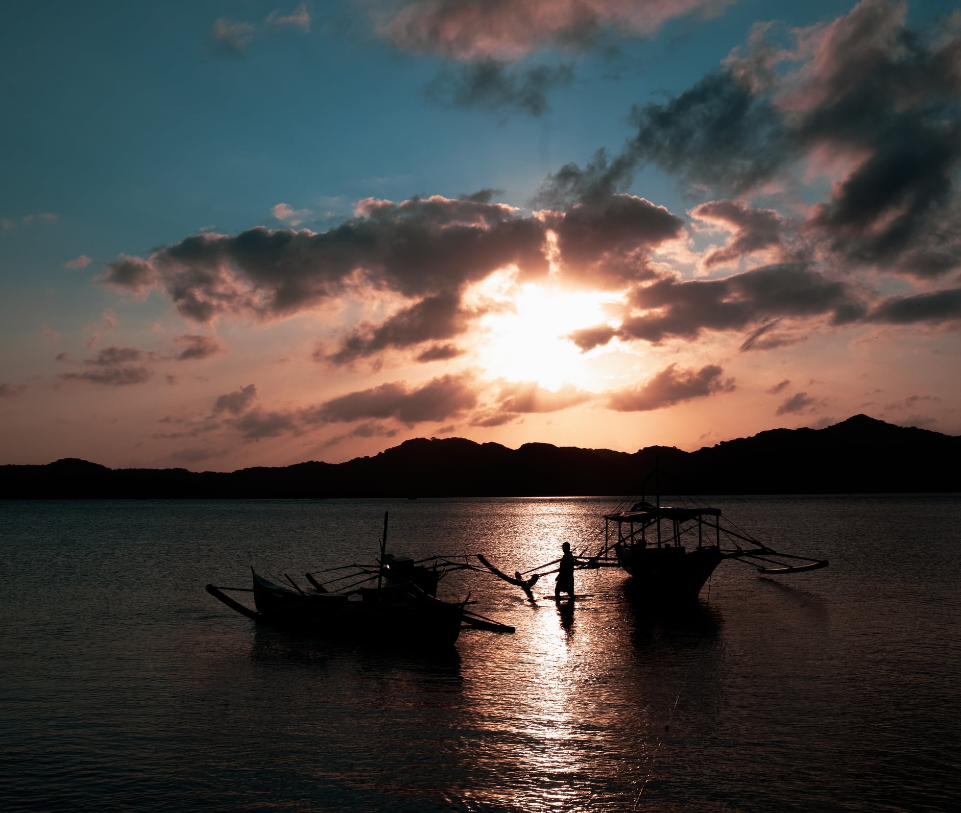Fishermans boats by the shore during sunset.