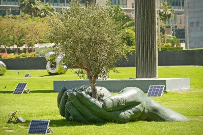 Hands holding tree sculpture. Symbol of conservation and protection of nature. Environment protection concept Global warming. Dubai, UAE - April, 2023. Image: Getty/MikeDot